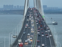 Traffic flows for several kilometers past the G15 Shenyang-Haikou Expressway of the Sutong Yangtze River Bridge in Changshu, China, on Septe...