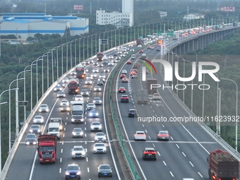 Traffic flows for several kilometers past the G15 Shenyang-Haikou Expressway of the Sutong Yangtze River Bridge in Changshu, China, on Septe...