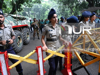 Bangladeshi police stand guard in front of the chief adviser's residence, Jamuna, as job seekers stage a demonstration on the road demanding...