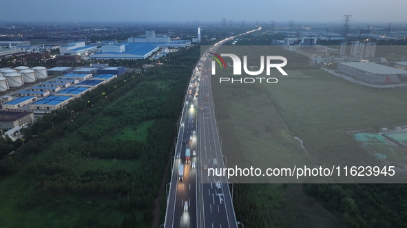 Traffic flows for several kilometers past the G15 Shenyang-Haikou Expressway of the Sutong Yangtze River Bridge in Changshu, China, on Septe...