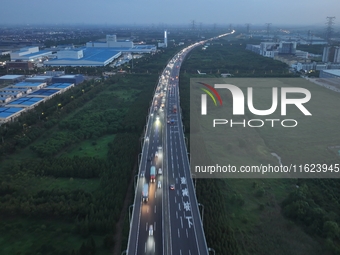 Traffic flows for several kilometers past the G15 Shenyang-Haikou Expressway of the Sutong Yangtze River Bridge in Changshu, China, on Septe...