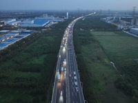 Traffic flows for several kilometers past the G15 Shenyang-Haikou Expressway of the Sutong Yangtze River Bridge in Changshu, China, on Septe...