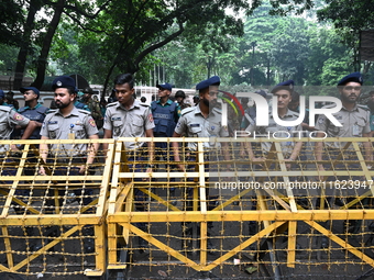 Bangladeshi police stand guard in front of the chief adviser's residence, Jamuna, as job seekers stage a demonstration on the road demanding...