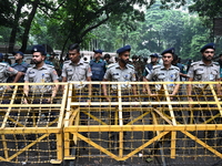 Bangladeshi police stand guard in front of the chief adviser's residence, Jamuna, as job seekers stage a demonstration on the road demanding...