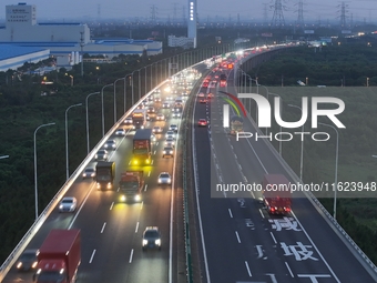 Traffic flows for several kilometers past the G15 Shenyang-Haikou Expressway of the Sutong Yangtze River Bridge in Changshu, China, on Septe...