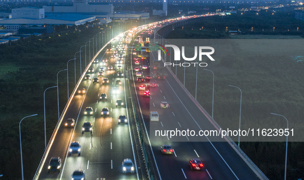 Traffic flows for several kilometers past the G15 Shenyang-Haikou Expressway of the Sutong Yangtze River Bridge in Changshu, China, on Septe...