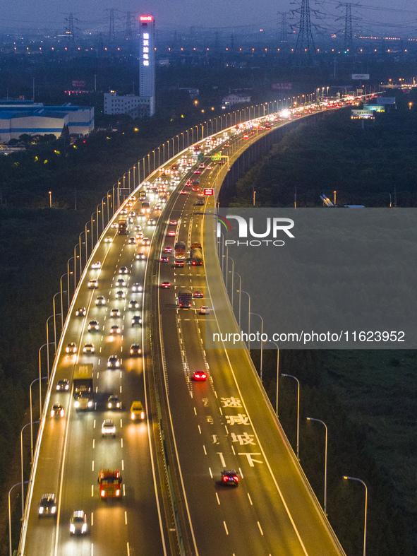 Traffic flows for several kilometers past the G15 Shenyang-Haikou Expressway of the Sutong Yangtze River Bridge in Changshu, China, on Septe...