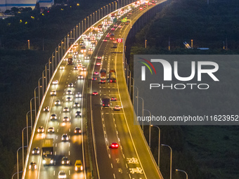 Traffic flows for several kilometers past the G15 Shenyang-Haikou Expressway of the Sutong Yangtze River Bridge in Changshu, China, on Septe...