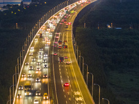 Traffic flows for several kilometers past the G15 Shenyang-Haikou Expressway of the Sutong Yangtze River Bridge in Changshu, China, on Septe...