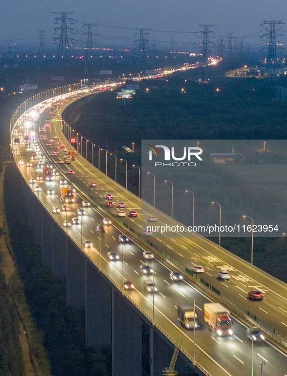 Traffic flows for several kilometers past the G15 Shenyang-Haikou Expressway of the Sutong Yangtze River Bridge in Changshu, China, on Septe...