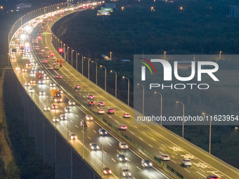 Traffic flows for several kilometers past the G15 Shenyang-Haikou Expressway of the Sutong Yangtze River Bridge in Changshu, China, on Septe...