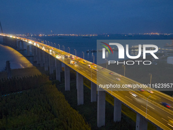 Traffic flows for several kilometers past the G15 Shenyang-Haikou Expressway of the Sutong Yangtze River Bridge in Changshu, China, on Septe...