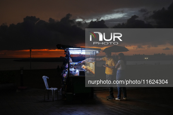 A street food vendor sells street food to customers at Galle Face promenade in Colombo, Sri Lanka, on September 30, 2024. 