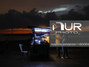 A street food vendor sells street food to customers at Galle Face promenade in Colombo, Sri Lanka, on September 30, 2024. (