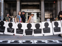 A dozen feminist activists perform with the names of some of Gisele Pelicot's rapists and with the message she recently said: ''Let shame ch...