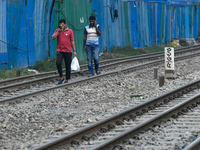 Pedestrians walk along a railway line while using their mobile phones in Dhaka, Bangladesh, on September 30, 2024. In Bangladesh, a signific...