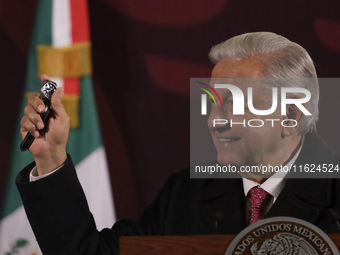 Andres Manuel Lopez Obrador, President of Mexico, gives his watch to a journalist during his last press conference at the National Palace in...