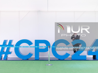 A man on the phone stands behind a giant #CPC24 at the Conservative Party Conference at the International Conference Centre in Birmingham, E...