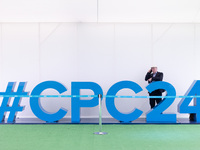 A man on the phone stands behind a giant #CPC24 at the Conservative Party Conference at the International Conference Centre in Birmingham, E...