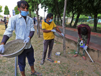 Workers use pesticides at a burrow to get rid of rats during a two-day campaign by Jaipur Development Authority to wipe out rodents at Alber...