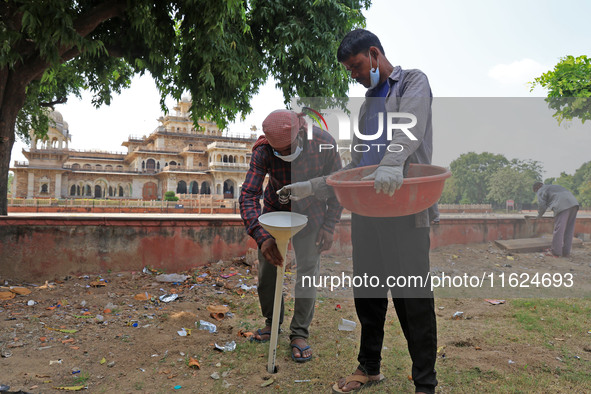 Workers use pesticides at a burrow to get rid of rats during a two-day campaign by Jaipur Development Authority to wipe out rodents at Alber...