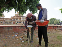 Workers use pesticides at a burrow to get rid of rats during a two-day campaign by Jaipur Development Authority to wipe out rodents at Alber...