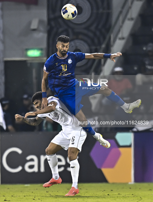 Paulo Silva (L) of Al Sadd SC and Ramin Rezaeian (top) of Esteghlal FC are in action during the AFC Champions League elite west football mat...