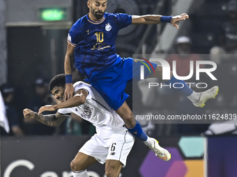 Paulo Silva (L) of Al Sadd SC and Ramin Rezaeian (top) of Esteghlal FC are in action during the AFC Champions League elite west football mat...