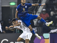 Paulo Silva (L) of Al Sadd SC and Ramin Rezaeian (top) of Esteghlal FC are in action during the AFC Champions League elite west football mat...