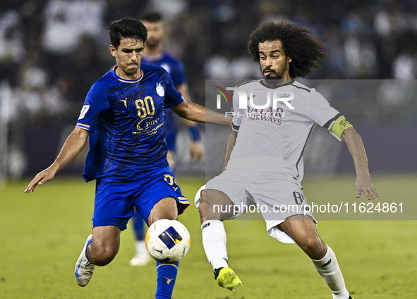 Akram Hassan Afif (R) of Al Sadd SC battles for the ball with Mohammadhossein Eslami of Esteghlal FC during the AFC Champions League elite w...