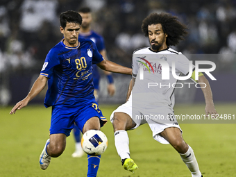 Akram Hassan Afif (R) of Al Sadd SC battles for the ball with Mohammadhossein Eslami of Esteghlal FC during the AFC Champions League elite w...