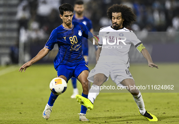 Akram Hassan Afif (R) of Al Sadd SC battles for the ball with Mohammadhossein Eslami of Esteghlal FC during the AFC Champions League elite w...