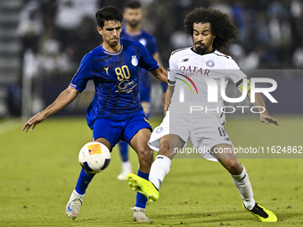 Akram Hassan Afif (R) of Al Sadd SC battles for the ball with Mohammadhossein Eslami of Esteghlal FC during the AFC Champions League elite w...