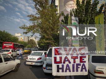 An elderly Iranian protester holds an anti-Israeli placard while taking part in a protest gathering to condemn an Israeli air strike against...