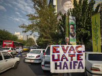 An elderly Iranian protester holds an anti-Israeli placard while taking part in a protest gathering to condemn an Israeli air strike against...