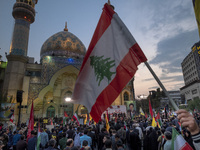 An Iranian protester waves a Lebanese flag while taking part in a protest gathering to condemn an Israeli air strike against Hezbollah's hea...