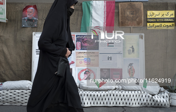 A veiled Iranian woman walks past a portrait of former commander of the Islamic Revolutionary Guard Corps' (IRGC) Quds Force, General Qassem...