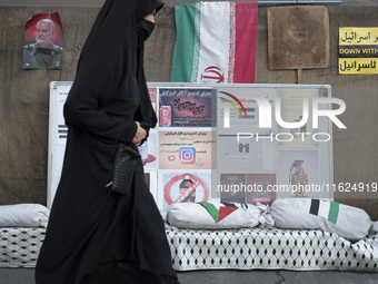 A veiled Iranian woman walks past a portrait of former commander of the Islamic Revolutionary Guard Corps' (IRGC) Quds Force, General Qassem...