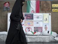 A veiled Iranian woman walks past a portrait of former commander of the Islamic Revolutionary Guard Corps' (IRGC) Quds Force, General Qassem...