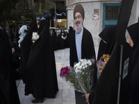 Veiled Iranian protesters hold flowers while standing next to an effigy of Lebanon's Hezbollah Secretary General, Hassan Nasrallah, during a...