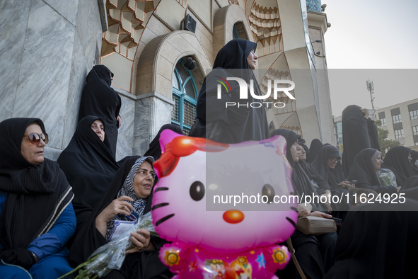 Veiled Iranian protesters stand behind a Hello Kitty-shaped balloon while taking part in a protest gathering to condemn an Israeli air strik...