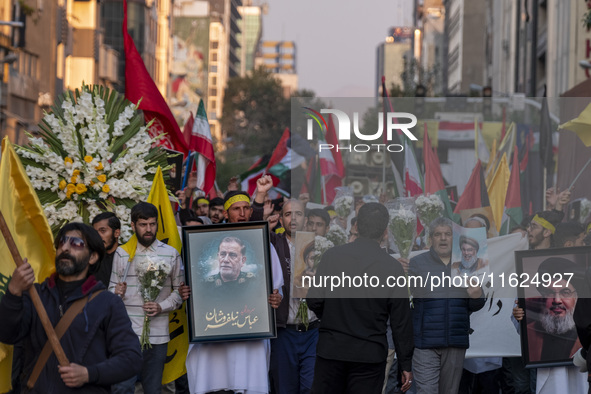 Iranian protesters carry portraits of Lebanon's Hezbollah Secretary General, Hassan Nasrallah, and an Islamic Revolutionary Guard Corps' (IR...