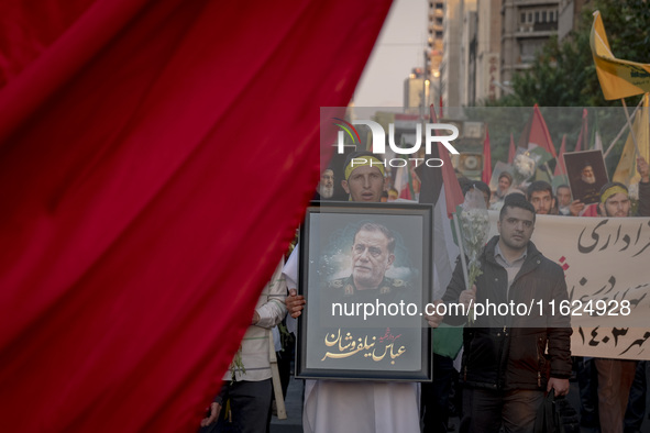 An Iranian protester carries a portrait of Islamic Revolutionary Guard Corps' (IRGC) Quds Force commander, General Abbas Nilforoushan, durin...