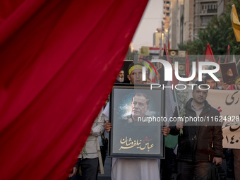 An Iranian protester carries a portrait of Islamic Revolutionary Guard Corps' (IRGC) Quds Force commander, General Abbas Nilforoushan, durin...