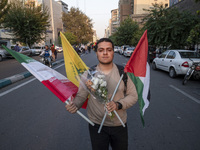 An Iranian protester carries an Iranian flag, a Palestinian flag, a flag of Lebanon's Hezbollah, and flowers while taking part in a protest...