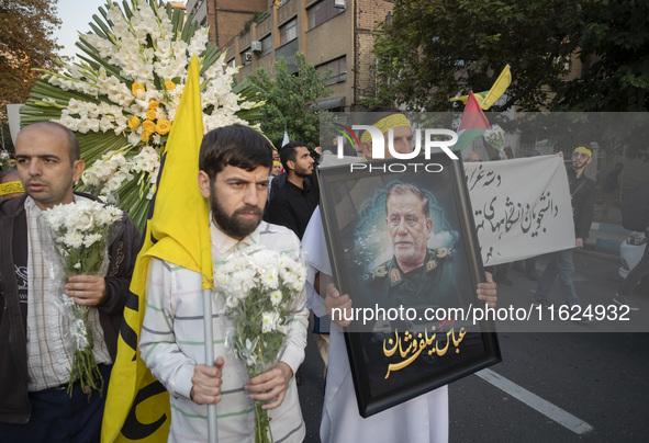 An Iranian protester carries a portrait of Islamic Revolutionary Guard Corps' (IRGC) Quds Force commander, General Abbas Nilforoushan, durin...