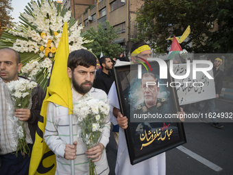 An Iranian protester carries a portrait of Islamic Revolutionary Guard Corps' (IRGC) Quds Force commander, General Abbas Nilforoushan, durin...