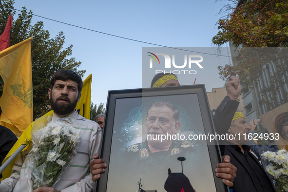 An Iranian protester carries a portrait of Islamic Revolutionary Guard Corps' (IRGC) Quds Force commander, General Abbas Nilforoushan, durin...