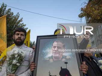 An Iranian protester carries a portrait of Islamic Revolutionary Guard Corps' (IRGC) Quds Force commander, General Abbas Nilforoushan, durin...