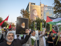 An Iranian protester carries a portrait of Lebanon's Hezbollah Secretary General, Hassan Nasrallah, during a protest gathering to condemn an...